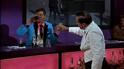 Man pouring another man a drink.
