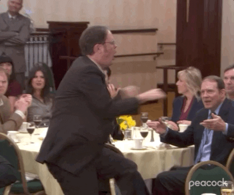 Man dancing along the seated people.