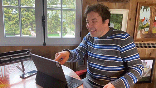 GIF of Jimmy Fallon laughing and shrugging in front of his laptop screen