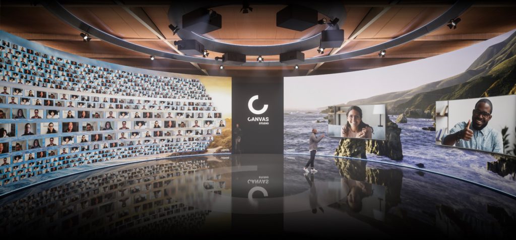 CANVAS studios 360-degree wraparound LED Screen featuring small zoom squares with peoples faces on the left, and a beach scene with two zoom screens on the right. A man stands on the stage in front of the screens.
