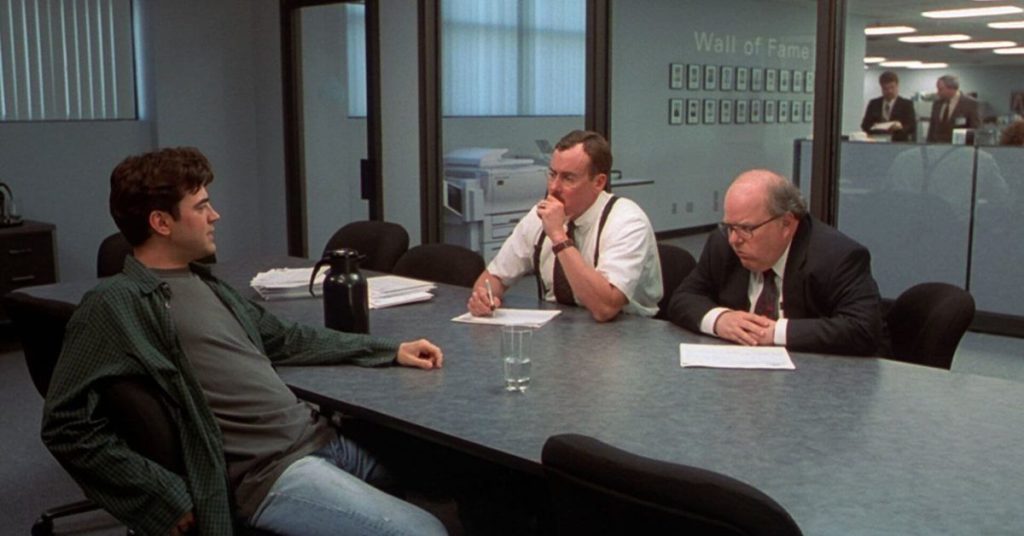 Three men in a conference room having a meeting.