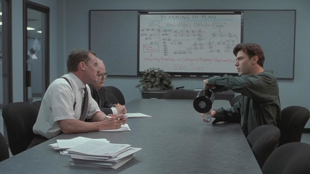 Three men sitting at conference table.